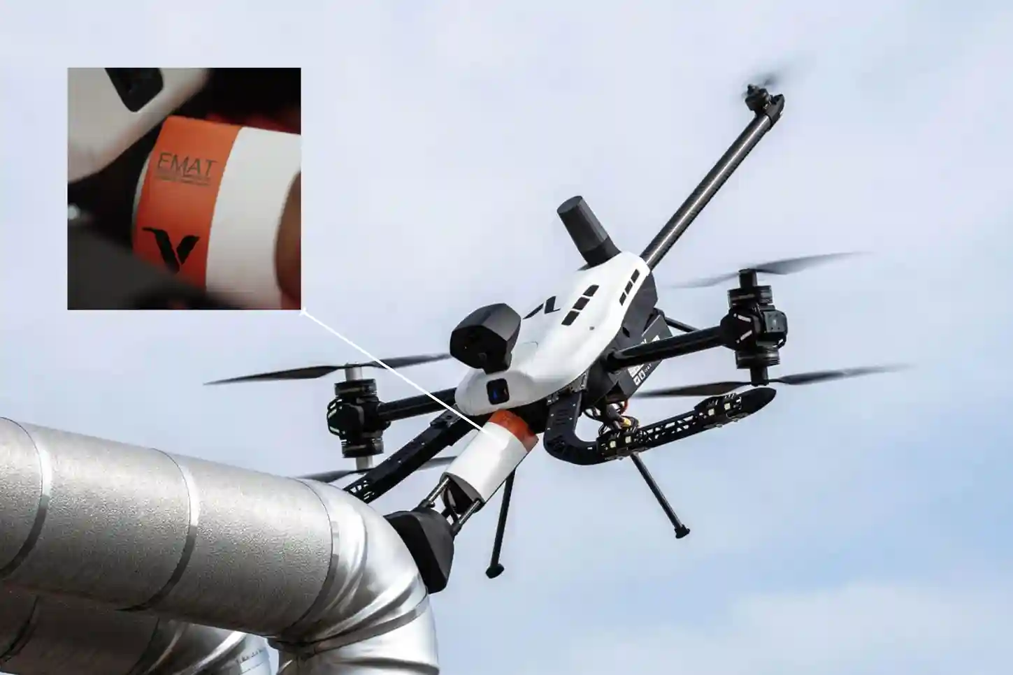 Voliro T drone with tiltable rotors performing a dry EMAT wall thickness inspection on a weathered industrial storage tank without couplant.