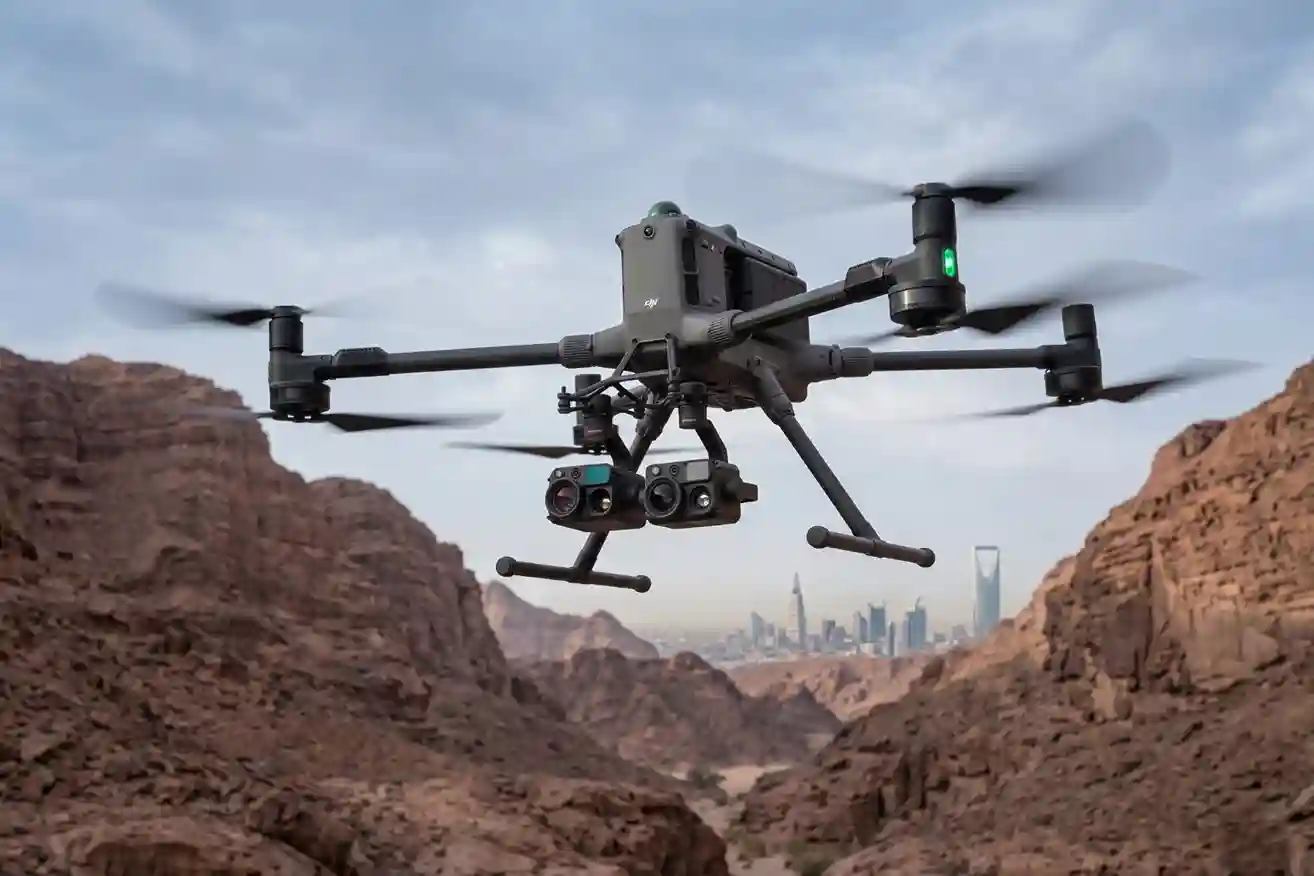 A DJI M400 drone flying over a rugged desert landscape with its thermal camera active.