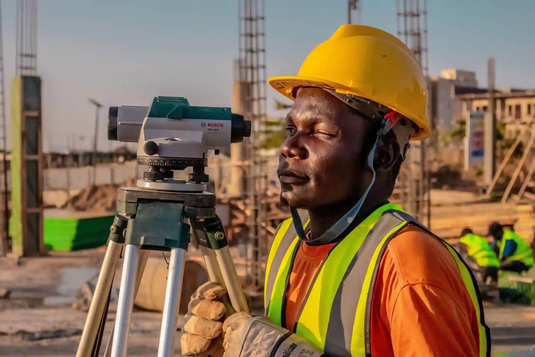 A professional land surveyor using a high-precision GPS satellite receiver on a tripod to map terrain for a utility power line project.