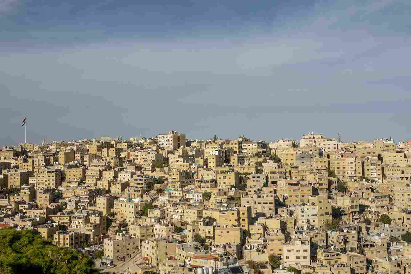 High-angle aerial view of a heavily congested urban area built over steep, rocky hillsides with closely packed buildings, dense infrastructure, and complex street layouts.