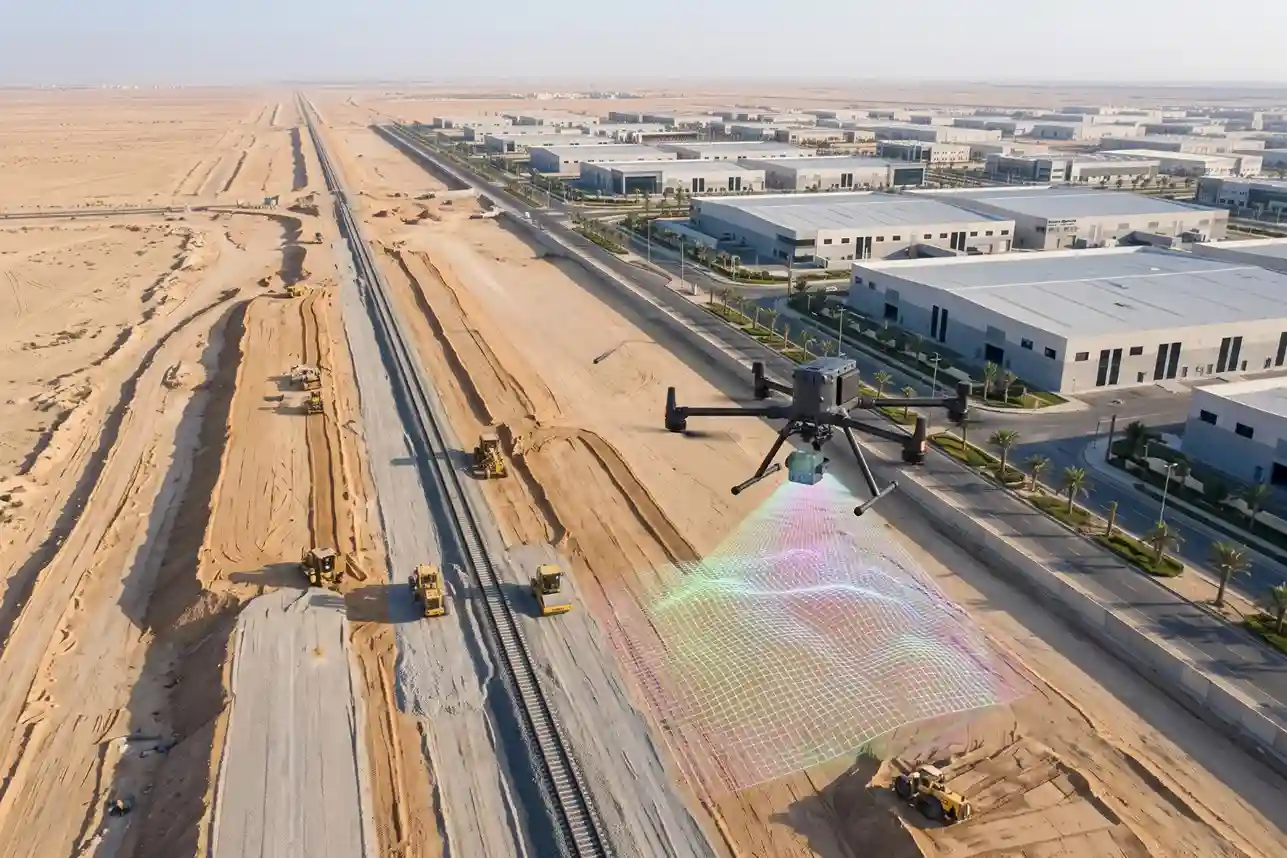 High-altitude aerial view of a single-track freight railway corridor undergoing civil construction in Dammam Second Industrial City.